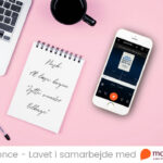 Skrivebord med notesblok og iphone med mofibo, hvor jytte fra marketing bliver afspillet